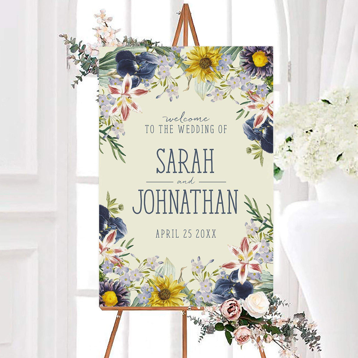 Watercolor spring wildflower wedding welcome sign with blue, yellow, lavender, and blush flowers surrounding an ivory background. The personalized design features the couple’s names and wedding date in blue-gray lettering.