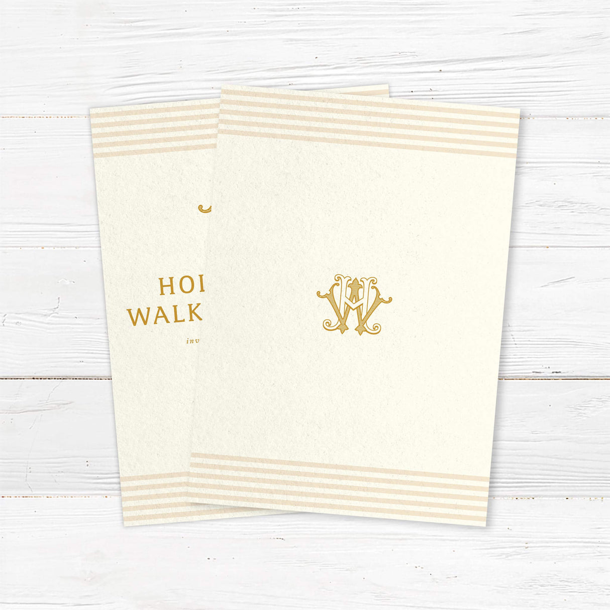 Elegant cream and gold wedding invitation featuring a decorative gold monogram crest at the top, horizontal neutral stripes on the top and bottom edges, and classic serif typography, ideal for formal weddings. - back side