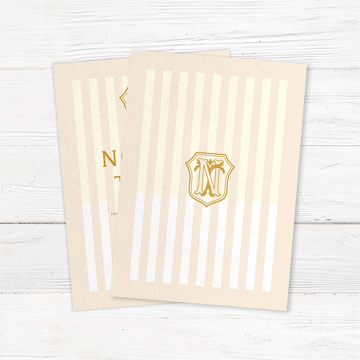 Cream and gold wedding invitation with vertical stripes and vintage-style crest monogram - back side
