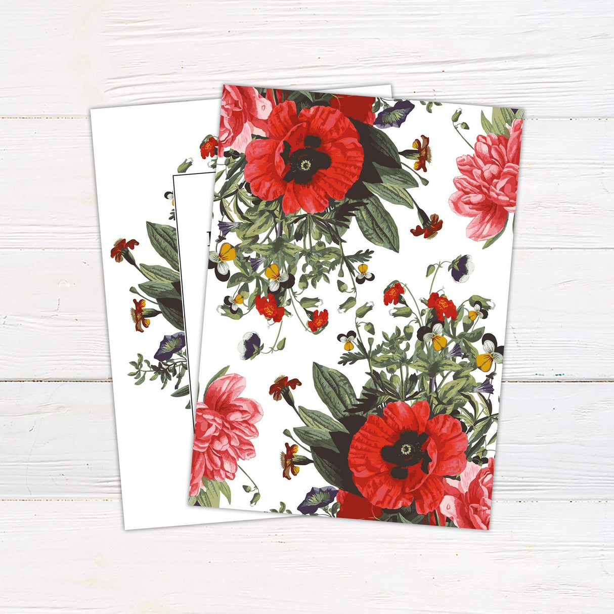 Wedding invitation with a bold bouquet of colorful summer florals surrounding a white text panel with serif and script fonts. - back side