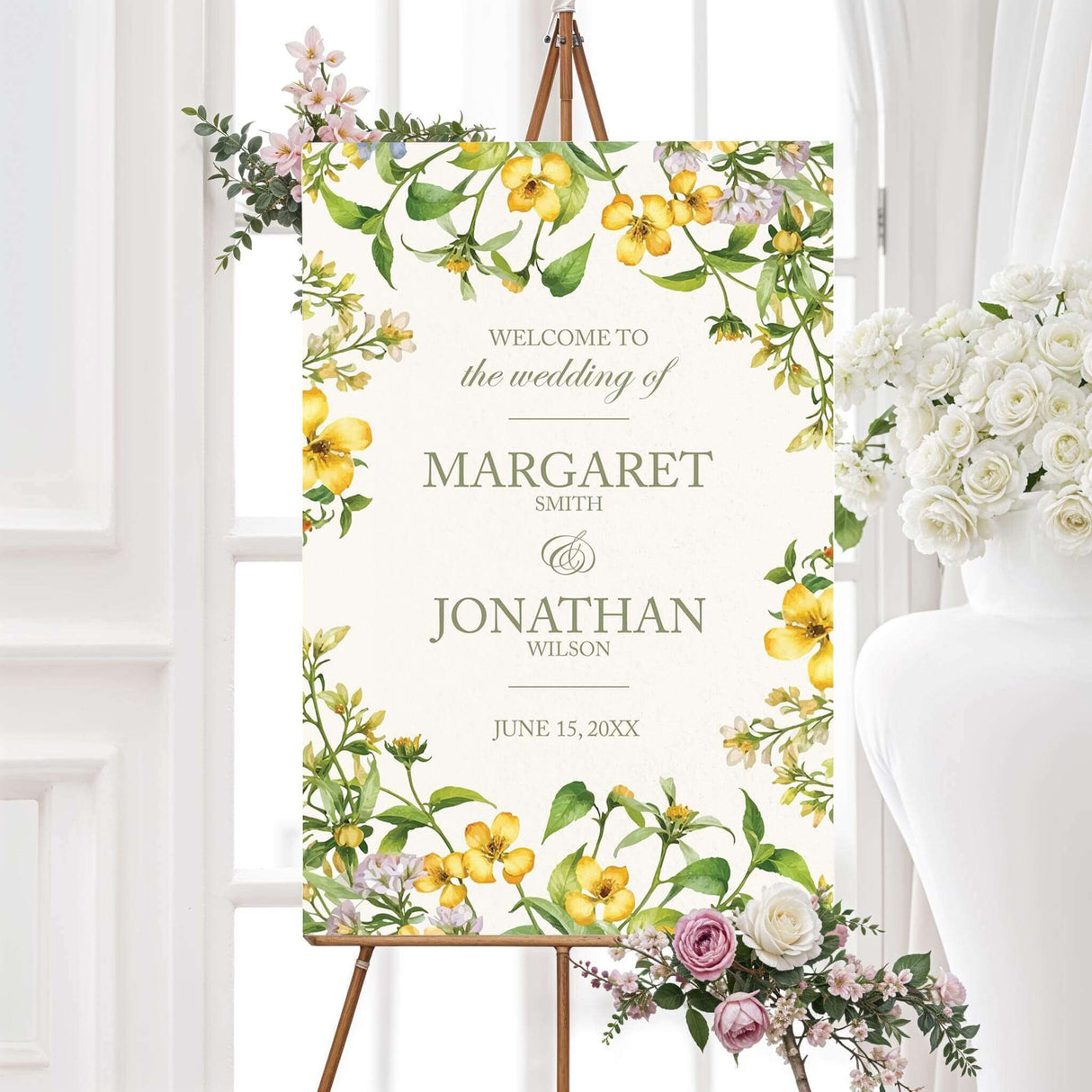 Elegant sign with a floral design featuring yellow and white flowers intertwined with green leaves. The text is in a sophisticated serif font, displaying the couple's names and wedding date.