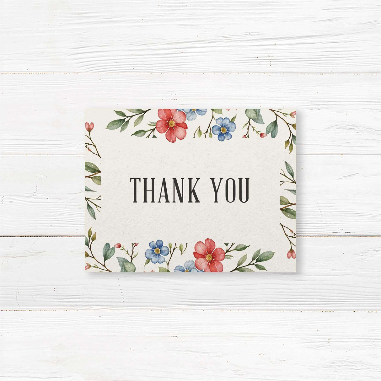 Elegant note card featuring a delicate watercolor floral design with red, blue, and pink flowers intertwined with green leaves. The layout is balanced with soft botanical elements framing the text, creating a romantic and timeless aesthetic.