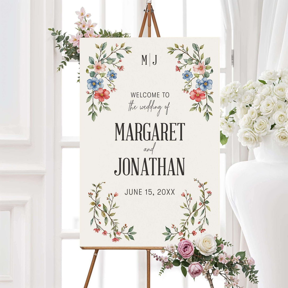 Elegant wedding welcome sign featuring a delicate watercolor floral design with red, blue, and pink flowers intertwined with green leaves. The layout is balanced with soft botanical elements framing the text, creating a warm and inviting aesthetic to greet guests at the ceremony or reception.