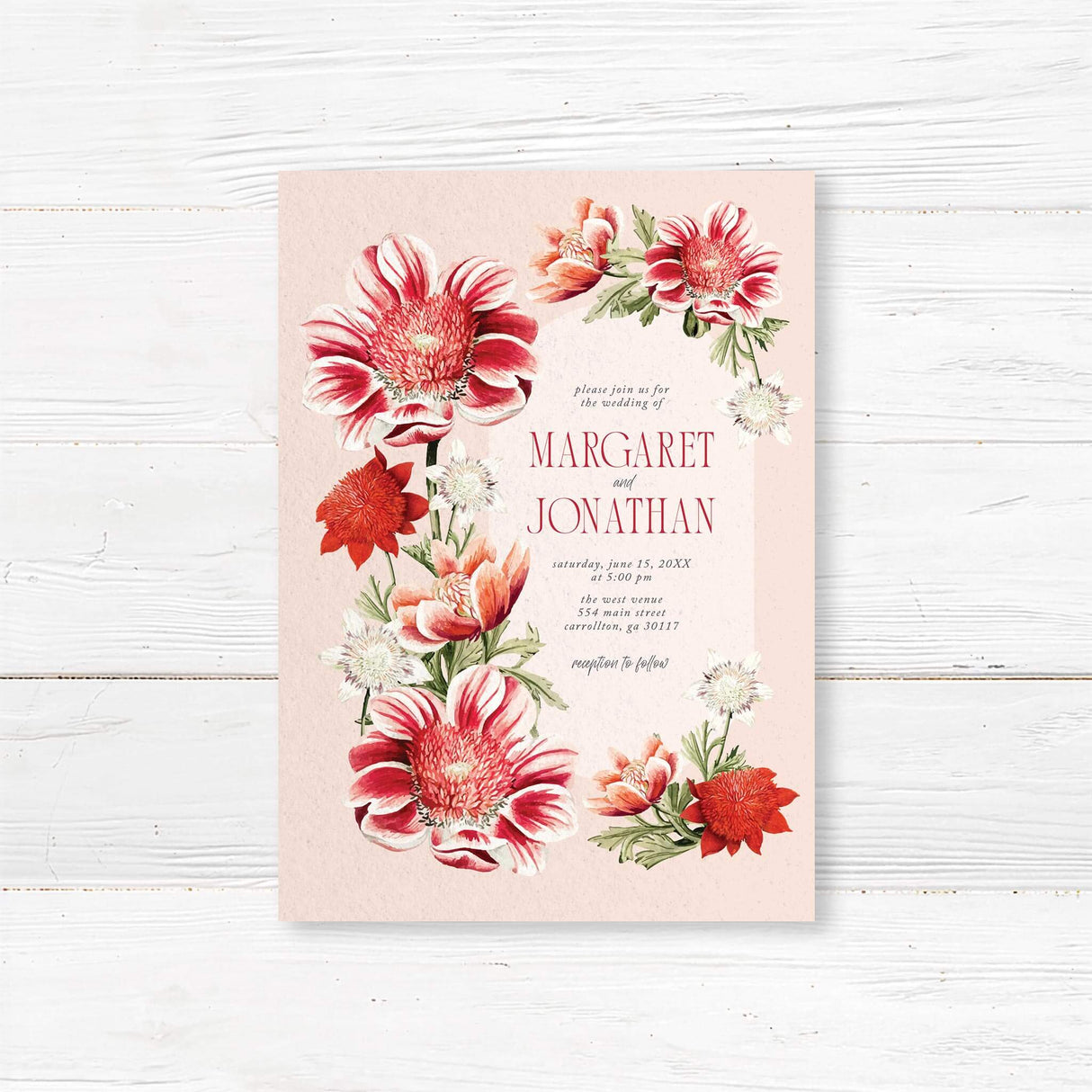 Wedding invitation with bold red and coral watercolor florals along the sides, elegant serif and script fonts, printed on textured white cardstock. Warm and romantic summer design.