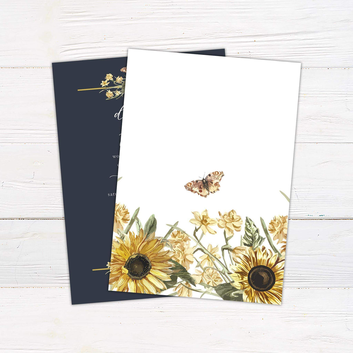 Wedding invitation with watercolor sunflowers, cream florals, and butterflies on a navy blue background with gold lines and script fonts.- back side