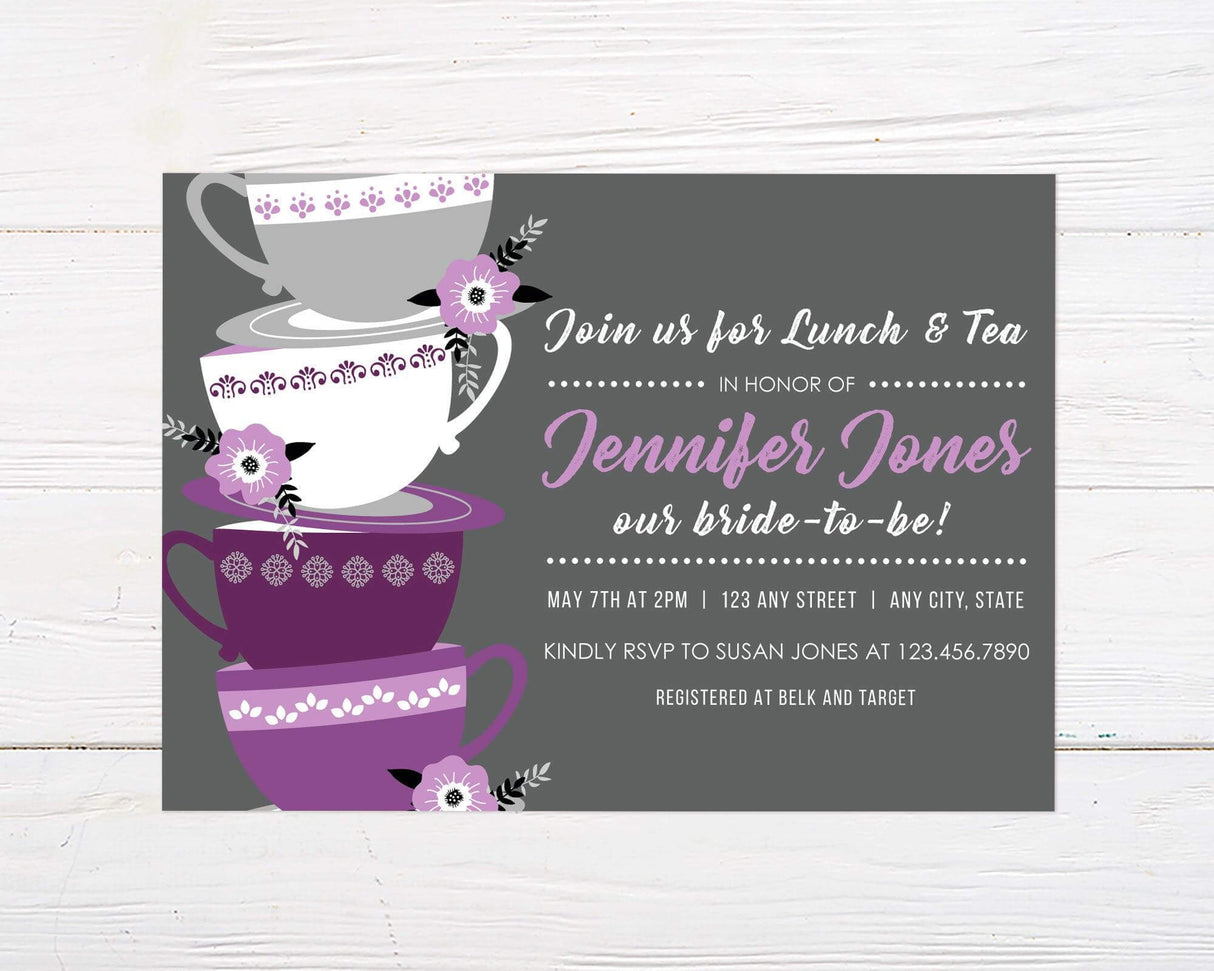 A tea cup-themed bridal shower invitation with stacked purple teacups and floral accents. The design features script text on a gray background.