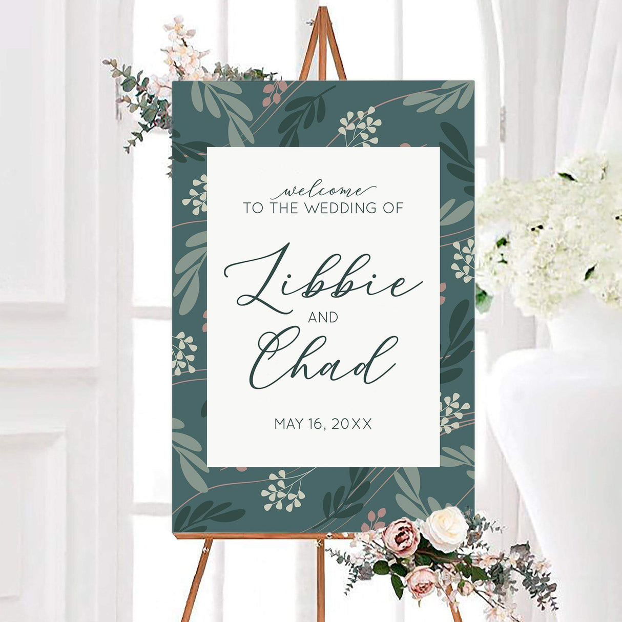 Teal leaf wedding welcome sign with sage, dark green, ivory, and blush leafy branches surrounding a white center panel. Elegant script displays the couple’s names with their personalized wedding date below.