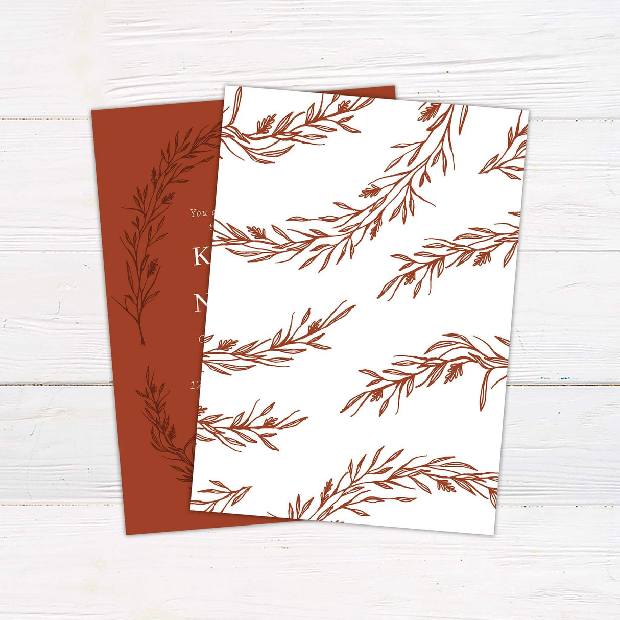 Burnt orange wedding invitation featuring a hand-drawn foliage wreath and white serif text, perfect for fall and rustic-themed weddings.- back side