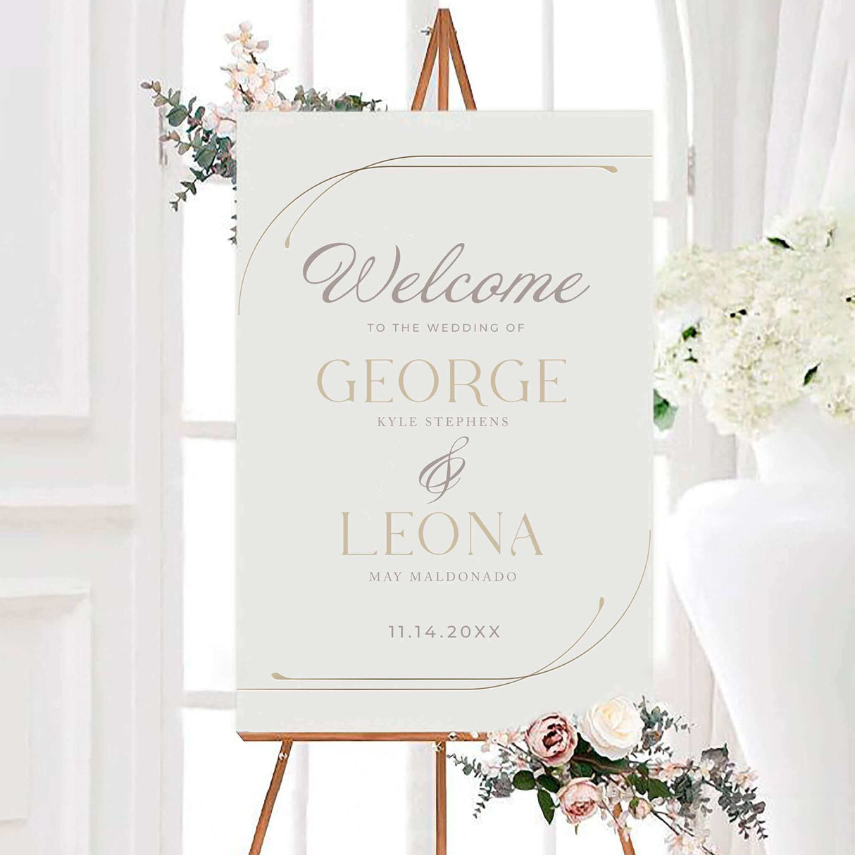 Large-format wedding welcome sign printed on white board, featuring elegant serif typography and thin gold curved frame lines at the corners. Personalized with the couple’s names and wedding date, this sign sets the tone for a modern, minimalist wedding ceremony or reception. Displayed on an easel with soft floral accents, it complements the Timeless Curve suite and is ideal for chic venues, luxury events, and refined wedding decor themes.