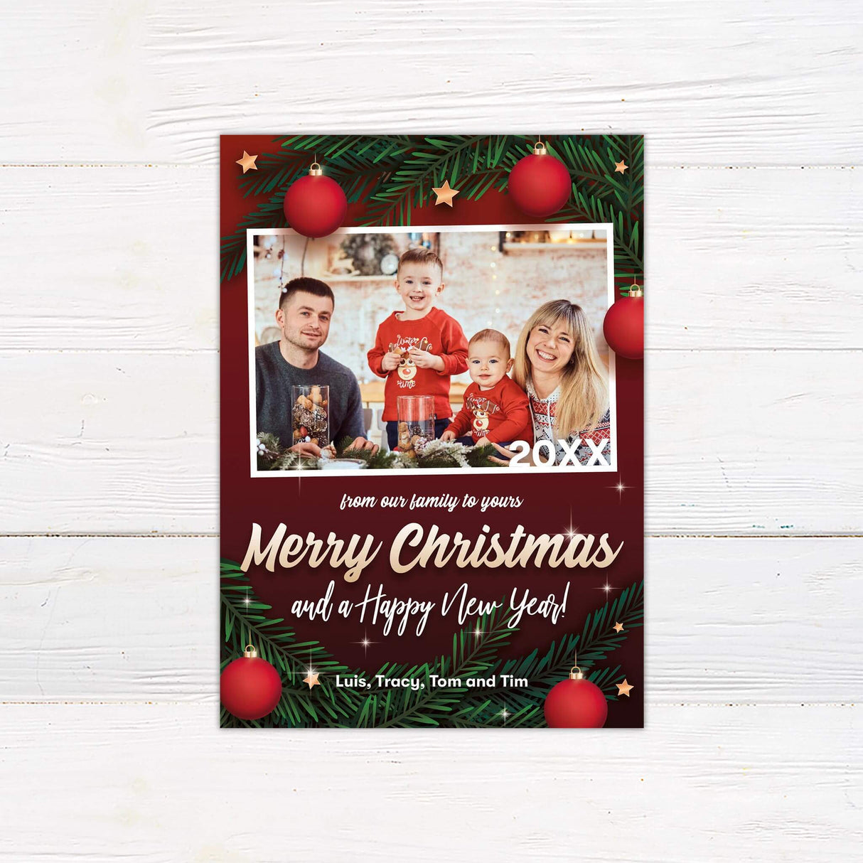 Family photo Christmas card with red background, pine branches, ornaments, gold and white festive fonts, and a “Merry Christmas and Happy New Year” message.