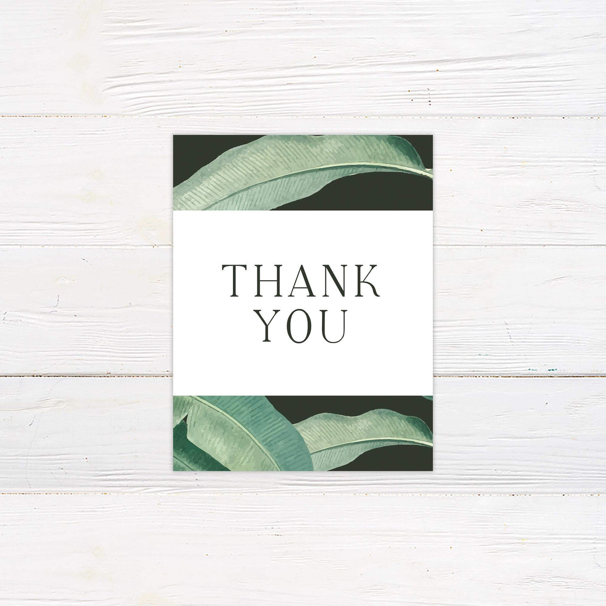 Thank you card with matching tropical greenery and elegant handwritten script.