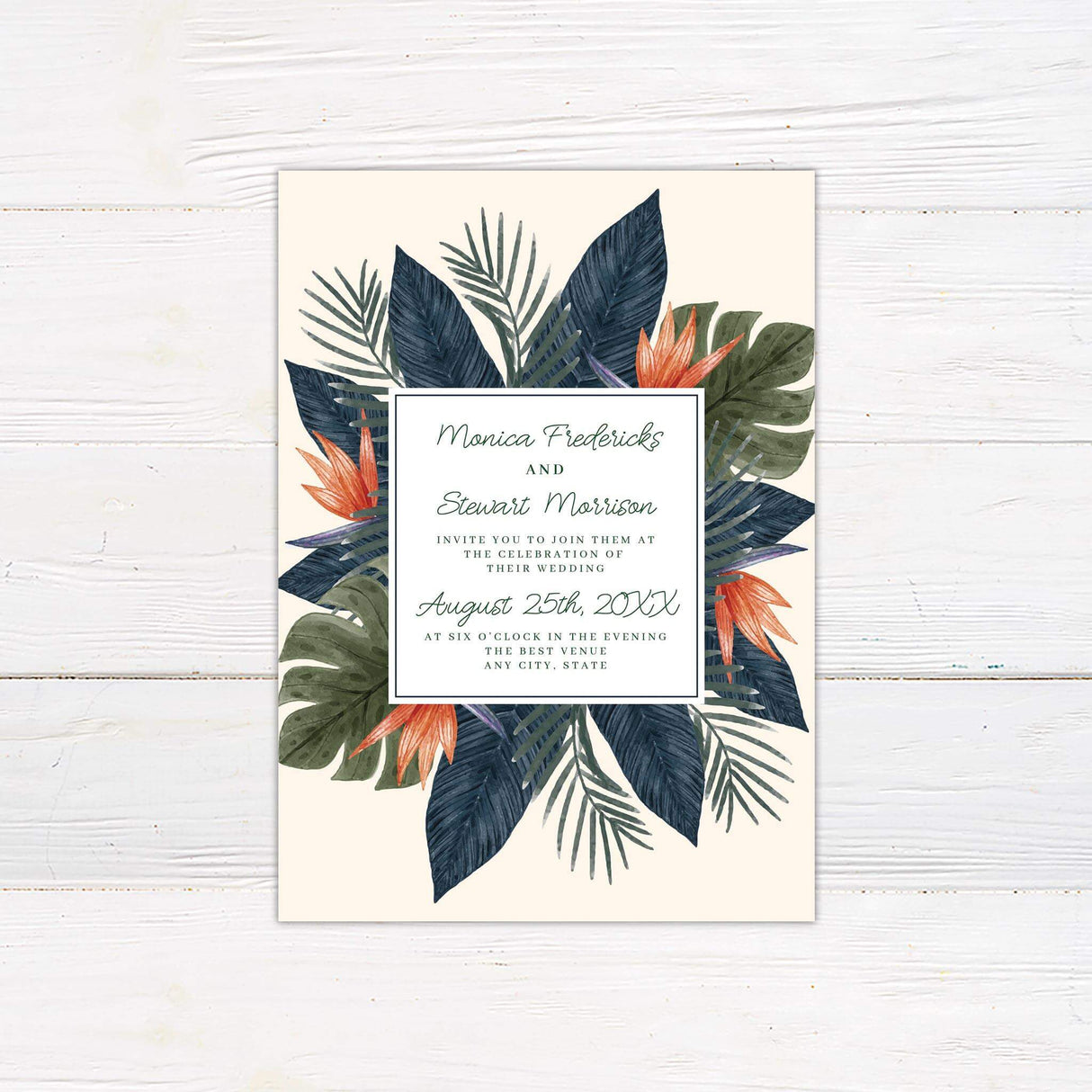 Tropical wedding invitation with colorful birds of paradise flowers and palm leaves surrounding a modern serif and script text layout on cream background.