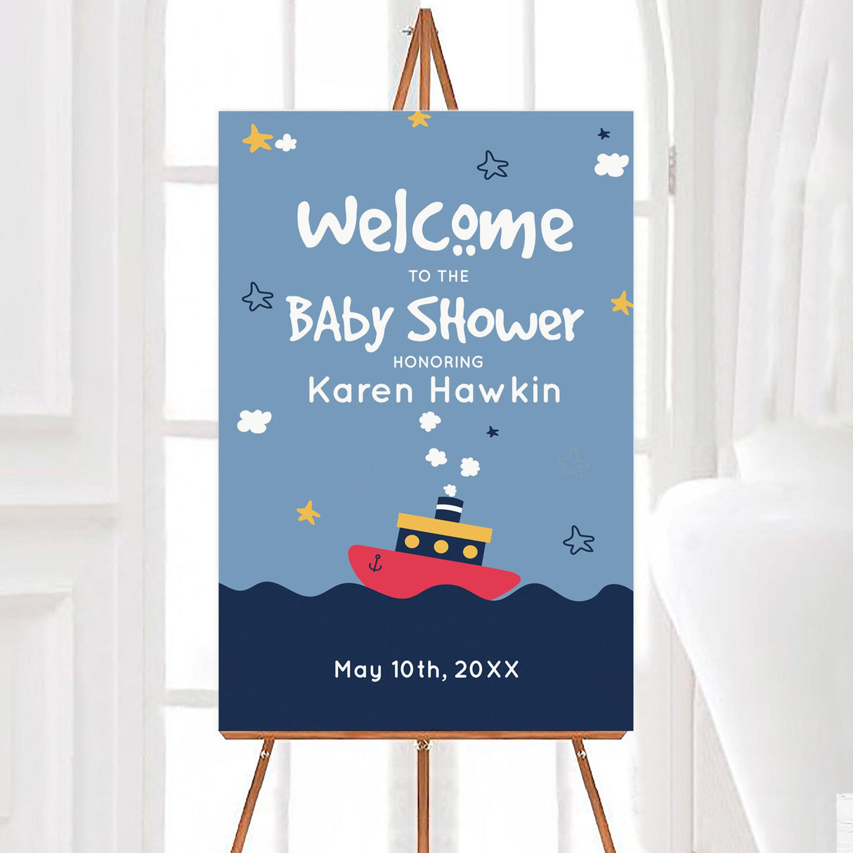 A tugboat baby shower welcome sign with a tugboat illustration on blue water. The design features stars, waves, and playful text.