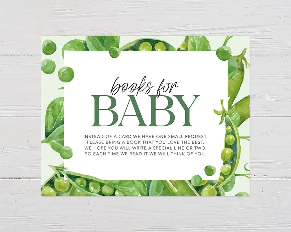 Two Peas in a Pod baby shower invitation with watercolor pea pods and "Books for Baby" message on wood background.