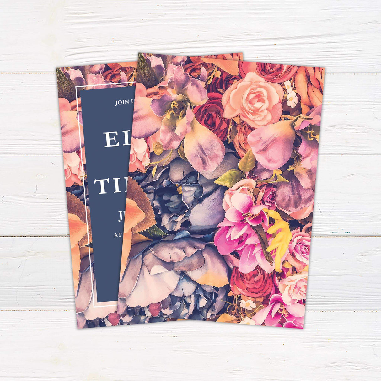 Bold wedding invitation with watercolor florals in pink, peach, and purple framing a navy blue center panel with elegant fonts. -back side