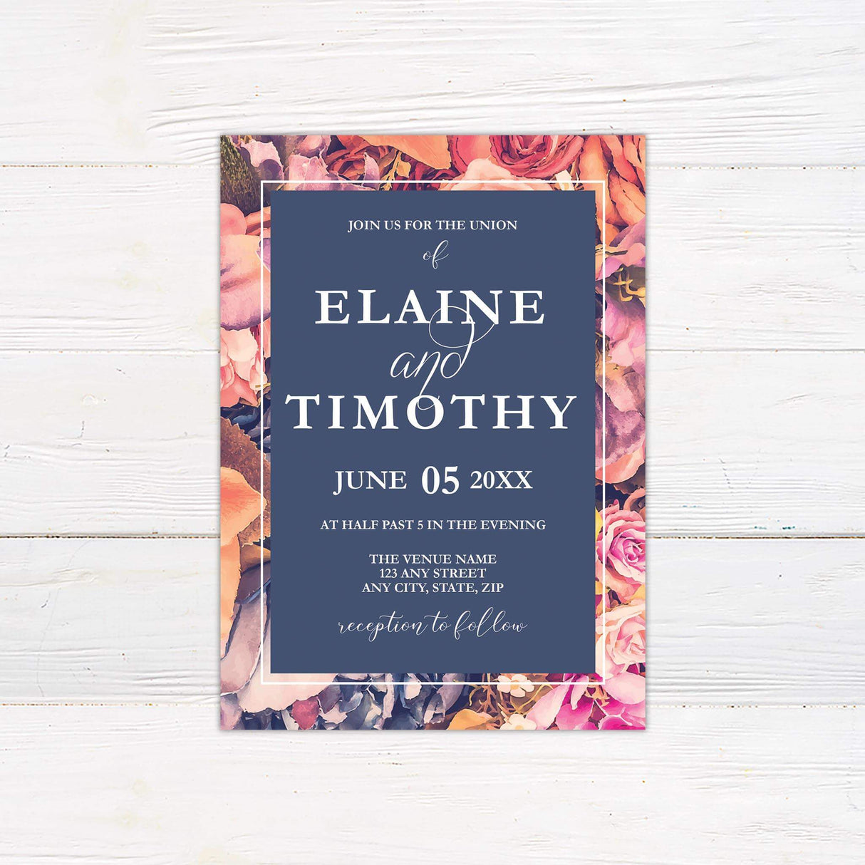 Bold wedding invitation with watercolor florals in pink, peach, and purple framing a navy blue center panel with elegant fonts.