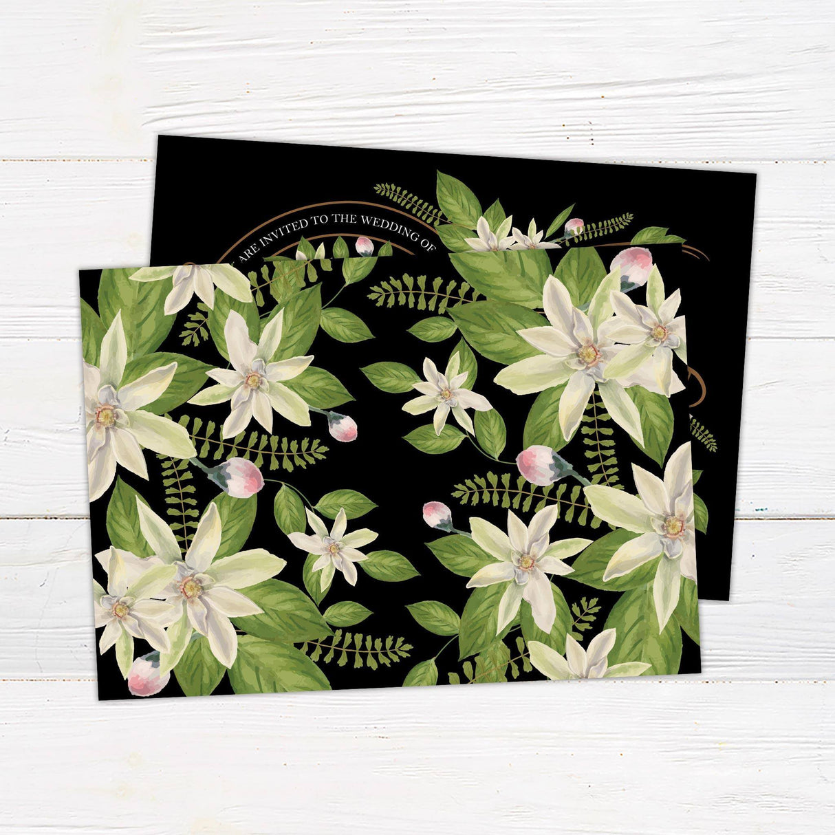 Dark background wedding invitation featuring white vintage flowers, green foliage, and elegant copper scrollwork with serif and script fonts.- back side