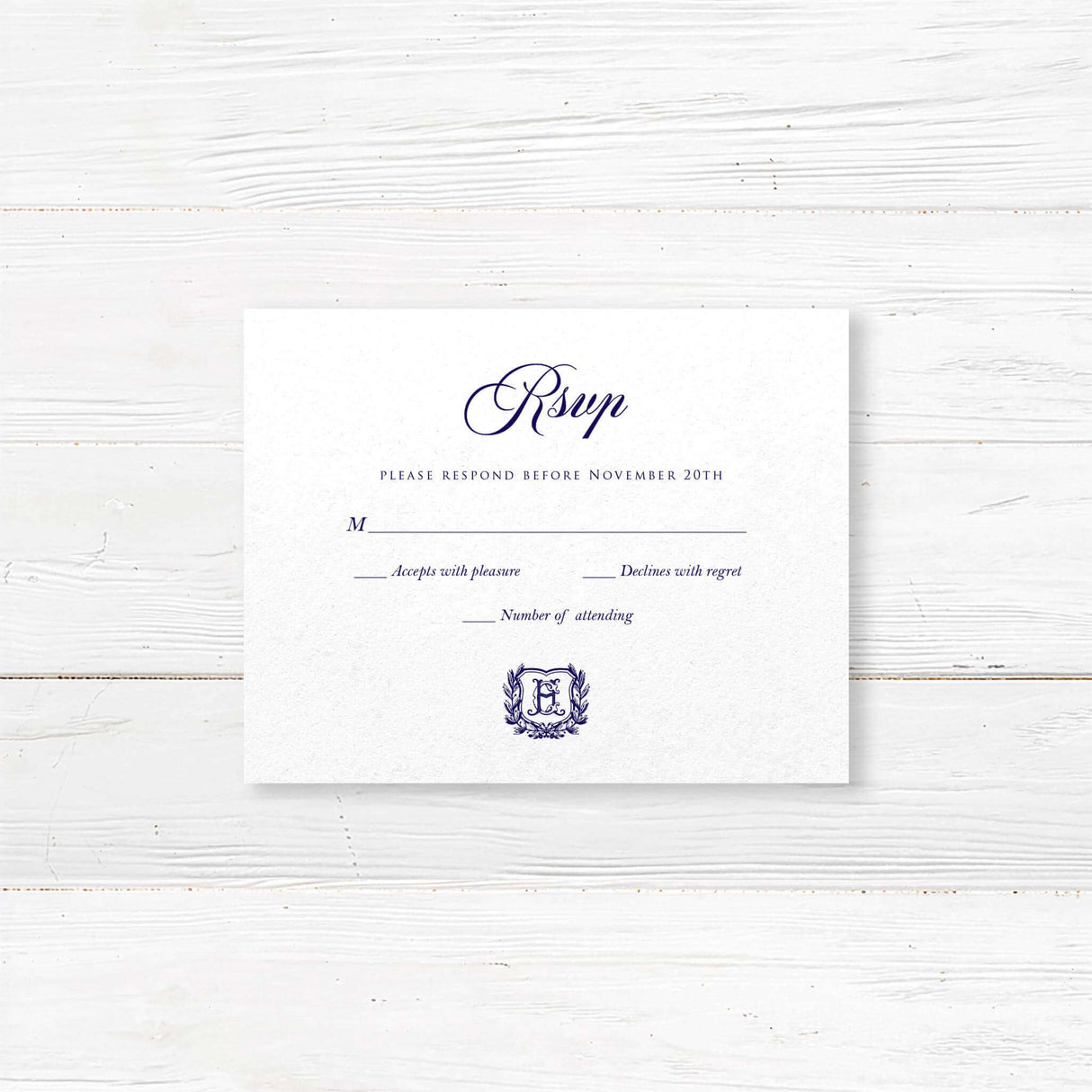 RSVP card with navy script and monogram crest design on white textured paper, for elegant traditional wedding stationery