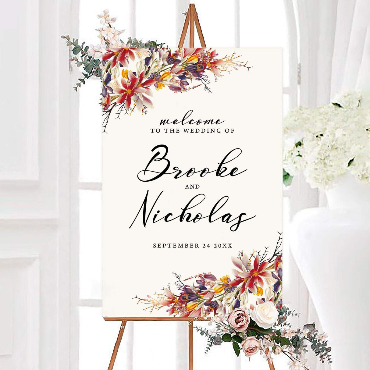 Chic wedding welcome sign featuring a striking floral arrangement in warm, rich autumn colors. A stylish and inviting way to greet guests at the ceremony or reception