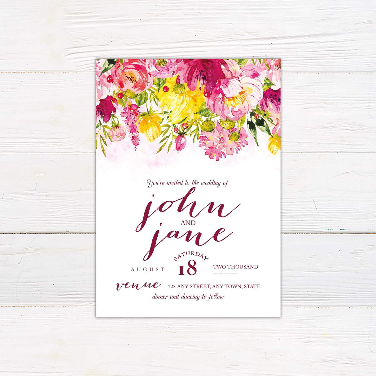 Modern wedding invitation with deep pink and blush watercolor florals on the top of the invitation wth mixed font design for text.