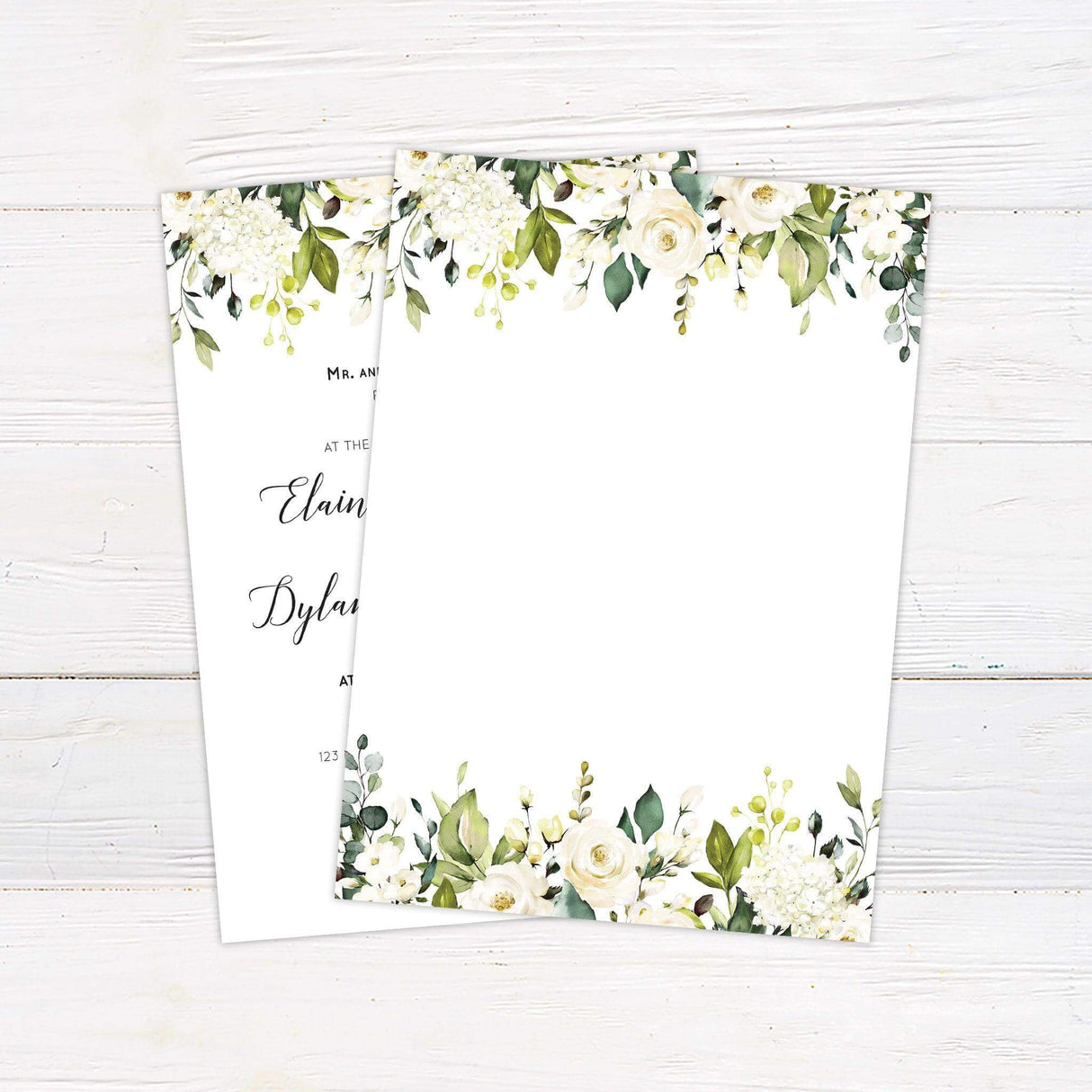Wedding invitation with white and cream roses, greenery floral border, and elegant script font. Back.