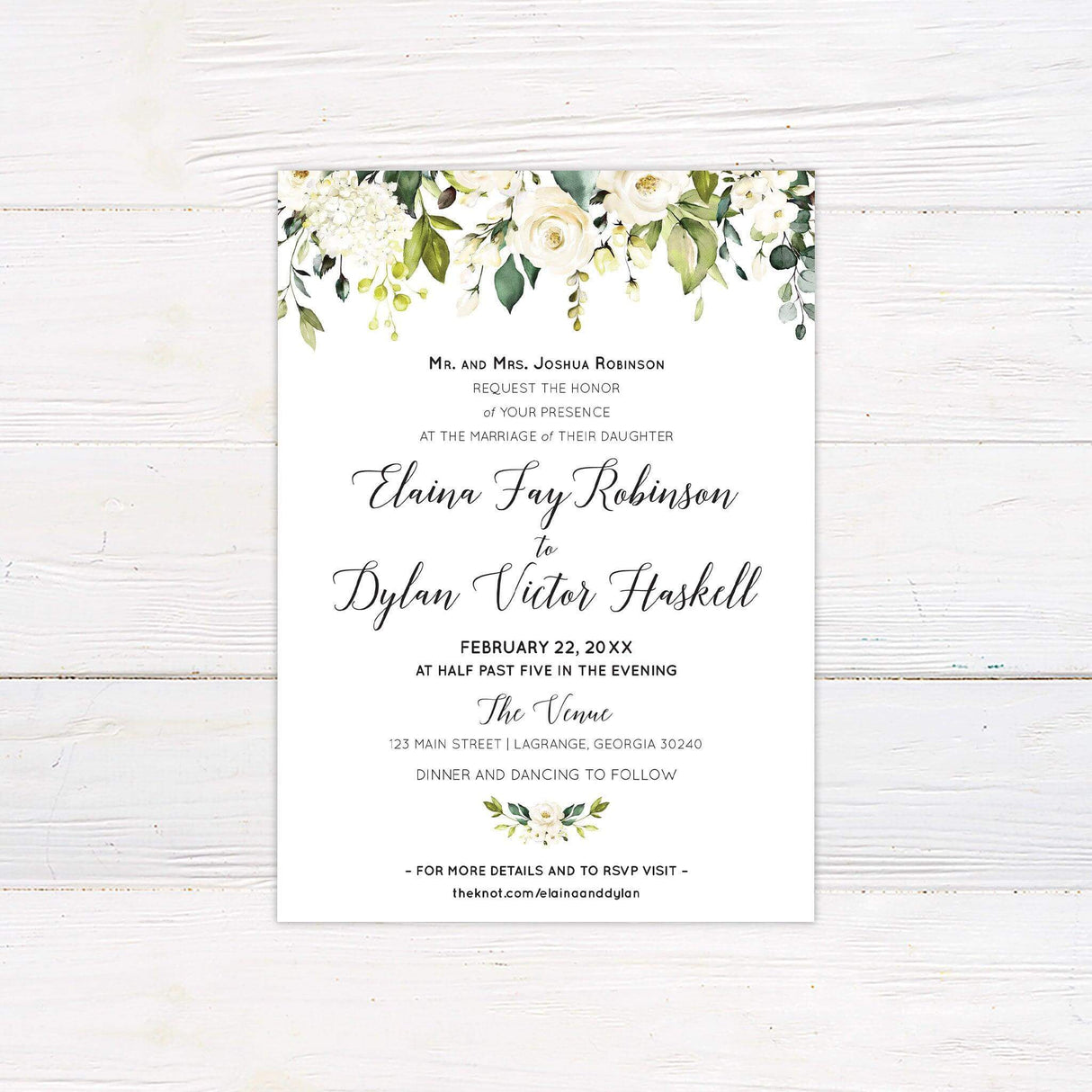 Wedding invitation with white and cream roses, greenery floral border, and elegant script font.