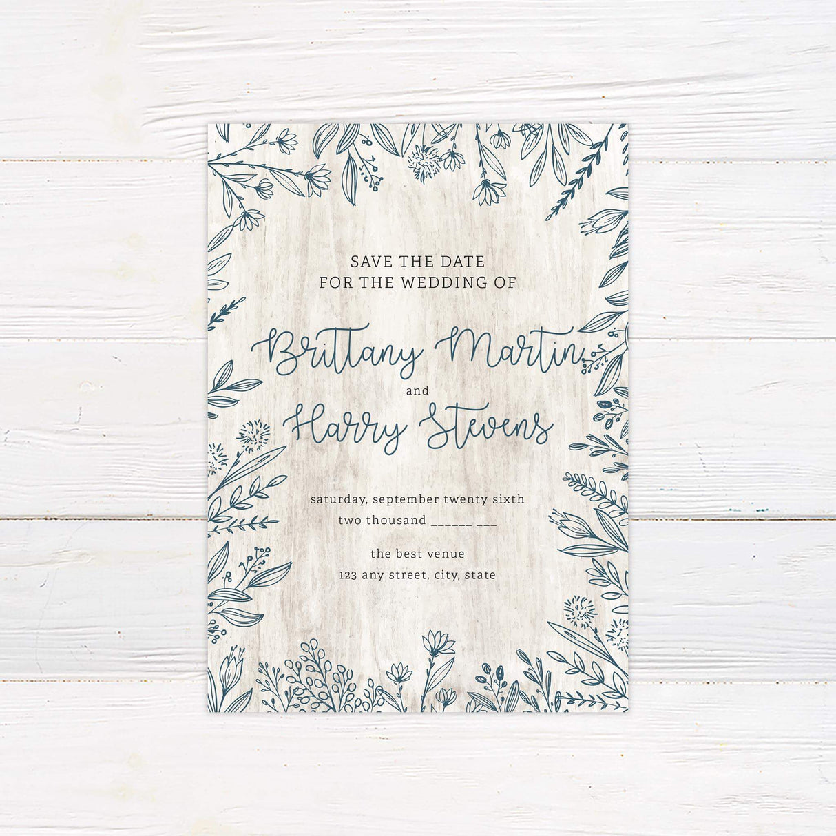 Save the Date card with coordinating florals and textured white wood background for a rustic look.