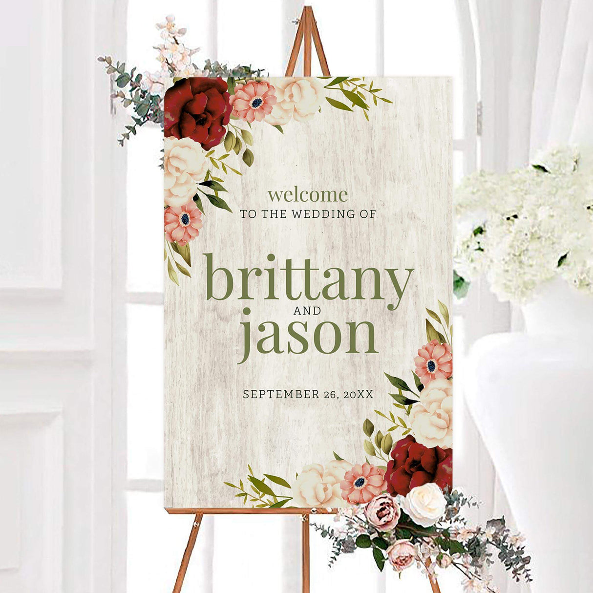 White wood floral wedding welcome sign featuring watercolor floral accents and elegant typography on a white wood-inspired background. A romantic rustic sign designed to welcome guests to a wedding ceremony or reception.