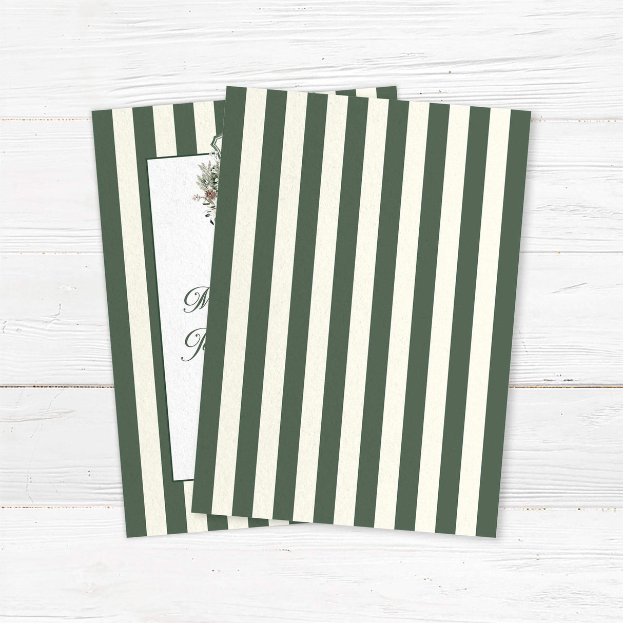 Winter wedding invitation featuring dark green and ivory vertical stripes, a white panel, floral monogram crest with greenery and roses, and elegant script and serif fonts for a formal winter wedding. - back side