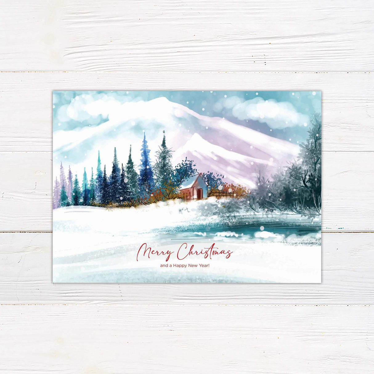 Watercolor winter holiday card with snowy mountain scene, pine trees, and red cabin reading "Merry Christmas and a Happy New Year" in elegant script.