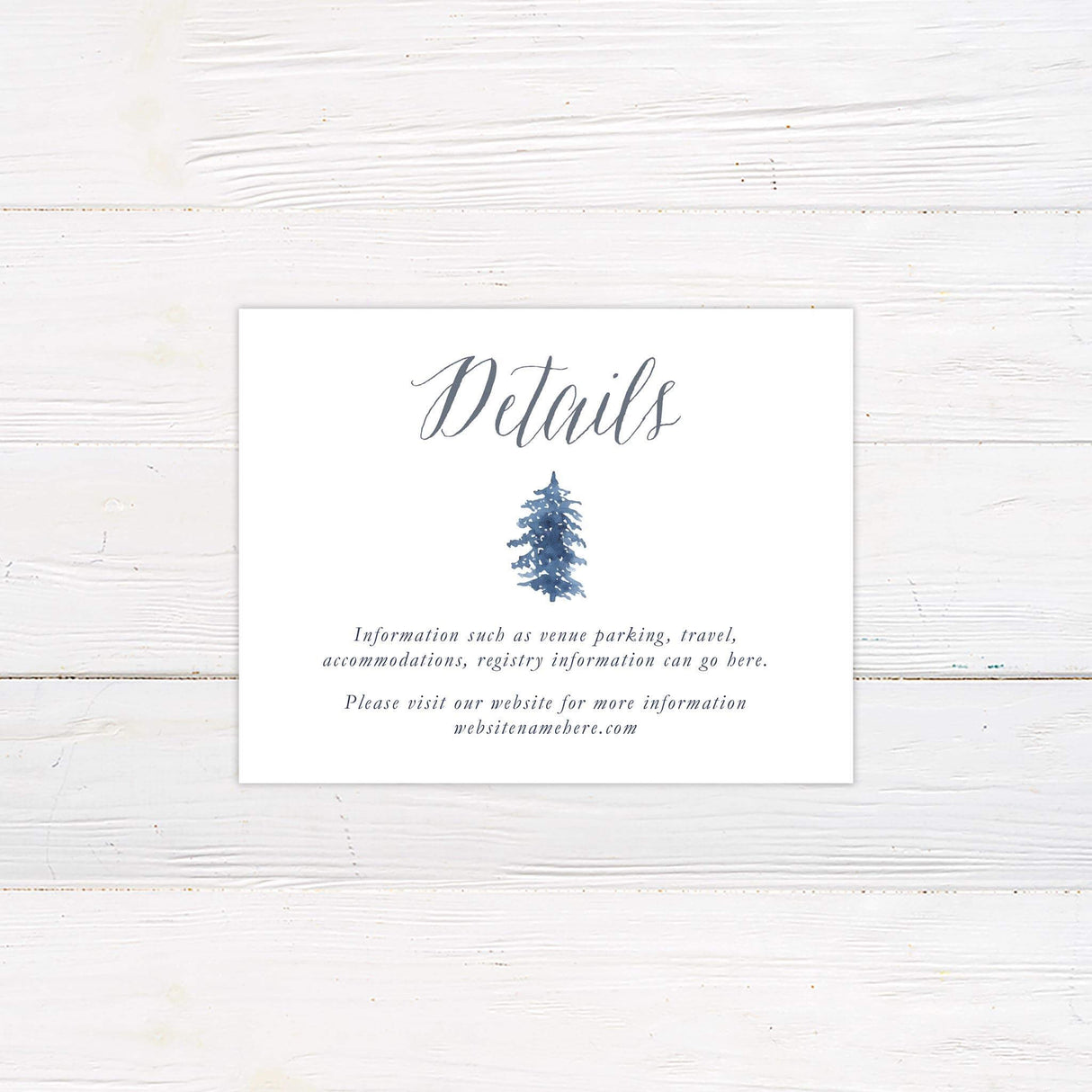 Wedding details card with snowy watercolor pine trees in blue and gray tones and elegant calligraphy.