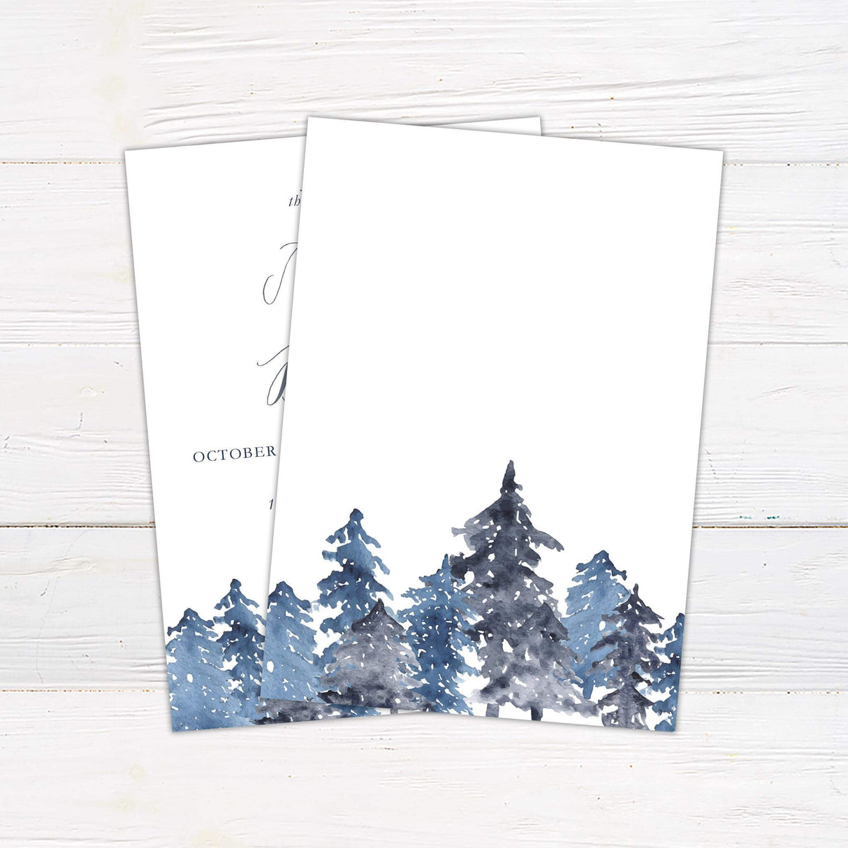 Wedding invitation with snowy watercolor pine trees in blue and gray tones and elegant calligraphy.  Back.