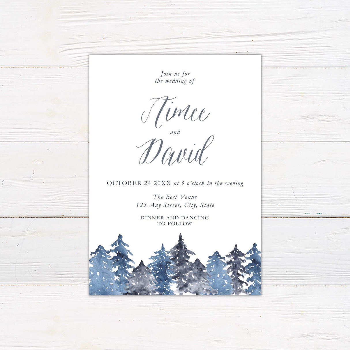 Wedding invitation with snowy watercolor pine trees in blue and gray tones and elegant calligraphy.