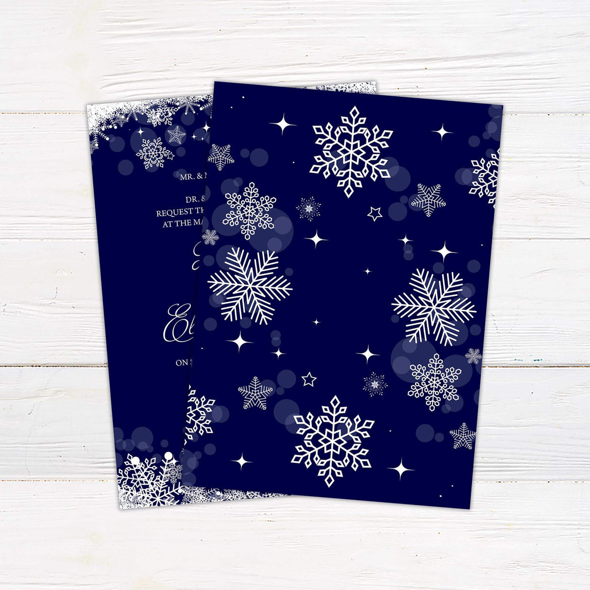 Navy blue wedding invitation with white snowflakes on top and bottom border and elegant script for a winter theme. Back.