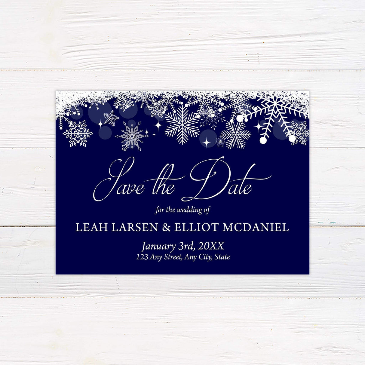 Navy blue save the date card with white snowflakes and elegant script for a winter theme