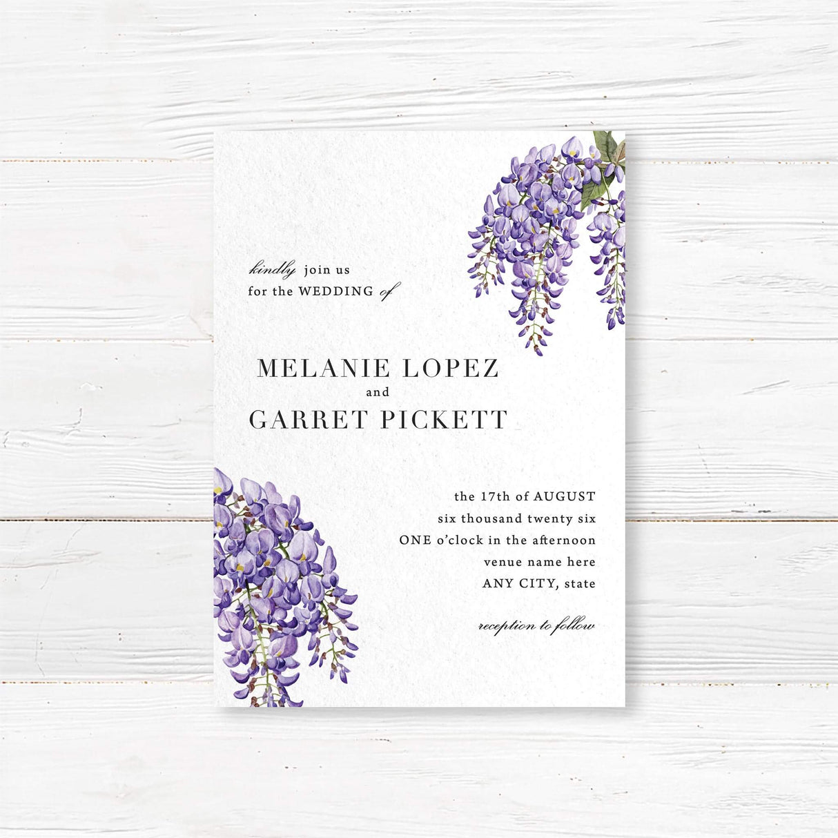 Wedding invitation with watercolor wisteria flowers in soft purple and lavender tones, paired with elegant serif fonts on white textured cardstock. Romantic floral design.