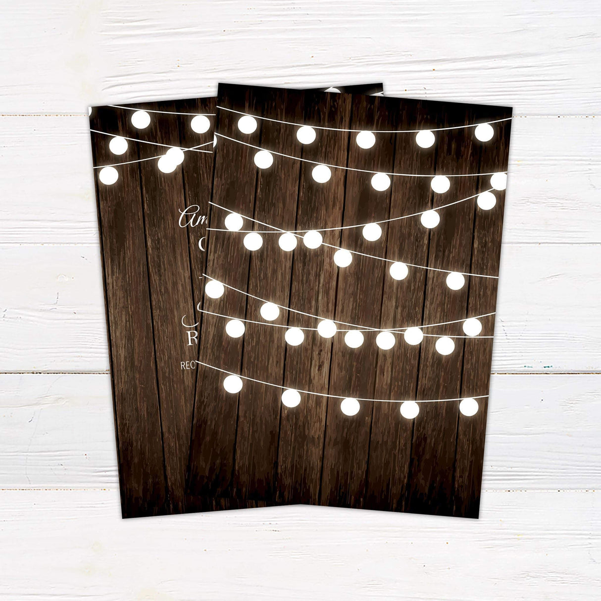 Rustic wedding invitation with wood background and glowing string lights, featuring script and serif fonts. - back side