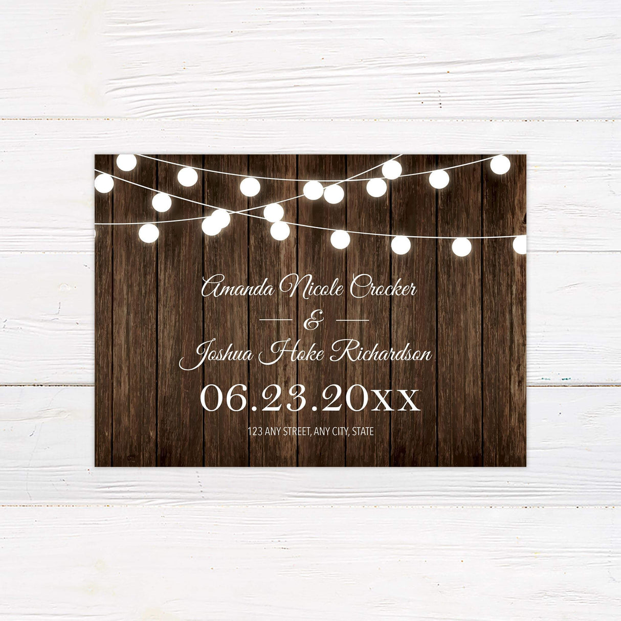 Save the Date card featuring a wood plank background and soft string lights with elegant typography.