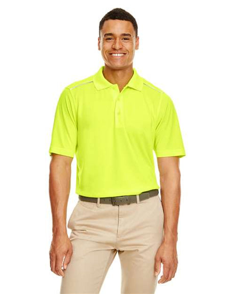 A yellow men’s CORE365 Radiant Performance piqué polo featuring a classic collar and short sleeves with reflective piping accents for added visibility. Designed with moisture-wicking fabric, it offers a sleek, athletic fit suitable for both casual wear and active use.