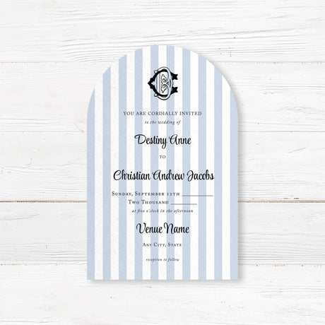 Arched wedding invitation with vertical light blue and white stripes, elegant black crest monogram at the top, and a mix of serif and script fonts for a classic and refined look, ideal for coastal or nautical wedding themes.