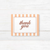 Printed thank you card with floral monogram crest, peach and terracotta stripes, and elegant fonts matching an autumn wedding suite in rustic fall colors.