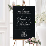 Wedding welcome sign with a black background, white serif and calligraphy fonts, and an ornate Celtic-style monogram crest. Matches formal weddings in the Celtic Monogram suite.