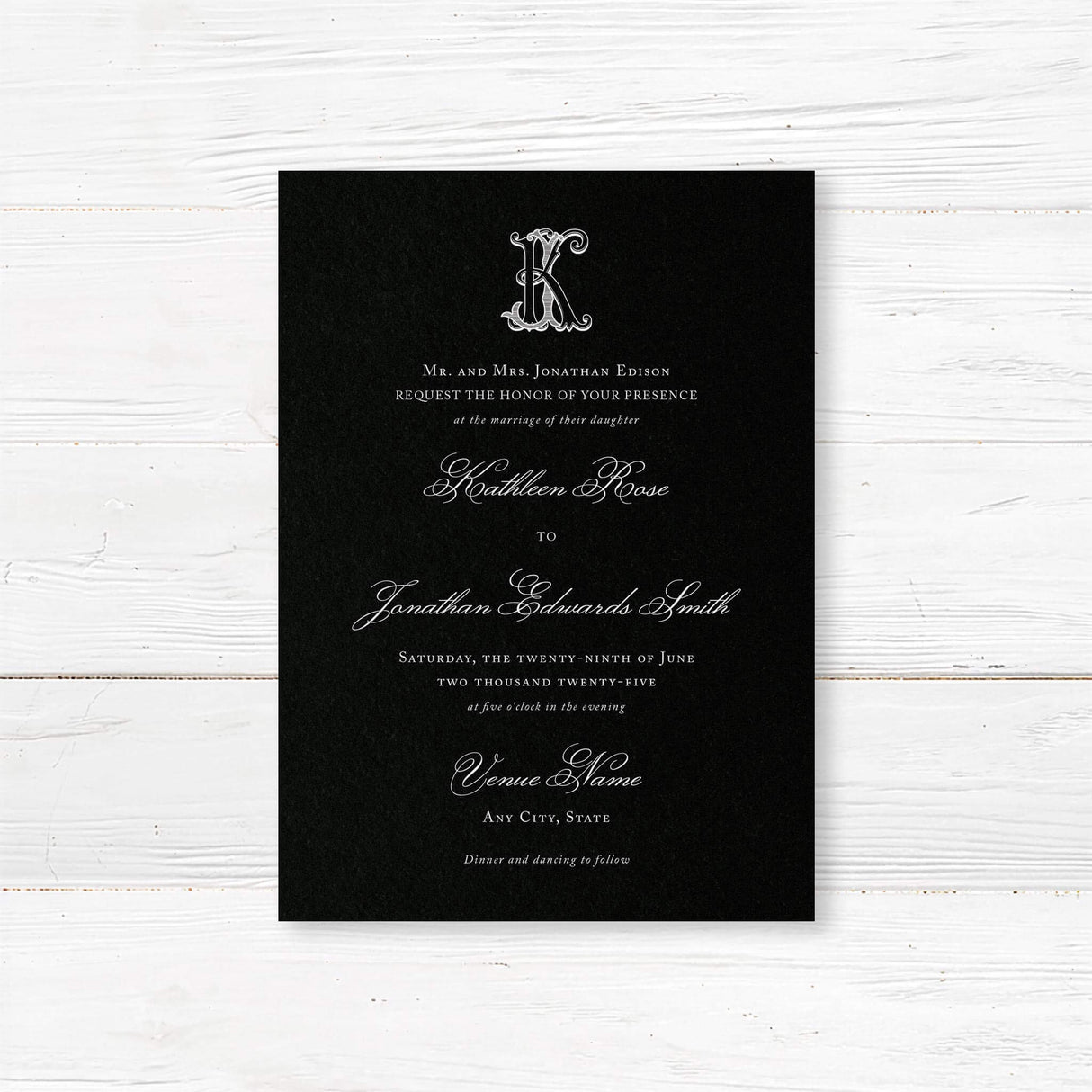 Wedding invitation with a black background, ornate Celtic monogram, and a blend of white script and serif fonts. A dramatic and elegant choice for formal or Celtic-inspired weddings.