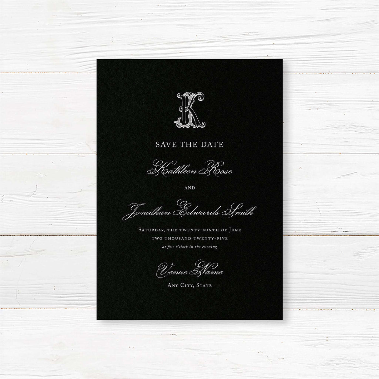 Save the Date card featuring a black background, ornate Celtic monogram crest, and elegant white serif and script fonts for formal and black-tie wedding themes.