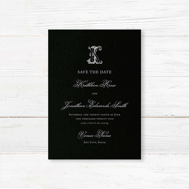 Save the Date card featuring a black background, ornate Celtic monogram crest, and elegant white serif and script fonts for formal and black-tie wedding themes.