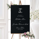 Wedding welcome sign featuring a solid black background, ornate white Celtic-style monogram, and a mix of script and serif fonts for a dramatic and elegant wedding entrance.