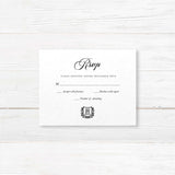 Wedding RSVP card with black background, white serif and script fonts, and a matching shield monogram design to coordinate with the Black Wreath Monogram invitation suite.