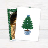 A personalized blue Christmas garland family holiday photo card framed with watercolor evergreen garland, blue and white ornaments, and a blue bow. The coordinating design features elegant blue script and a decorated Christmas tree with matching blue accents. - vertical back view.