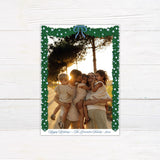 A personalized blue Christmas garland family holiday photo card framed with watercolor evergreen garland, blue and white ornaments, and a blue bow. The coordinating design features elegant blue script and a decorated Christmas tree with matching blue accents. - vertical front view.