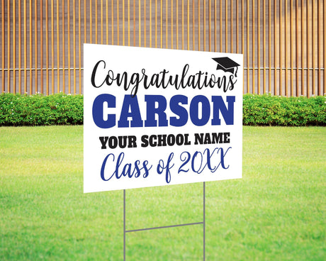 Custom graduation yard sign with bold name design in blue and black, featuring a congratulatory message, a graduation cap graphic, and customizable school name and class year. Printed on durable Coreplast plastic, available in single or double-sided options. Perfect for high school and college graduates.